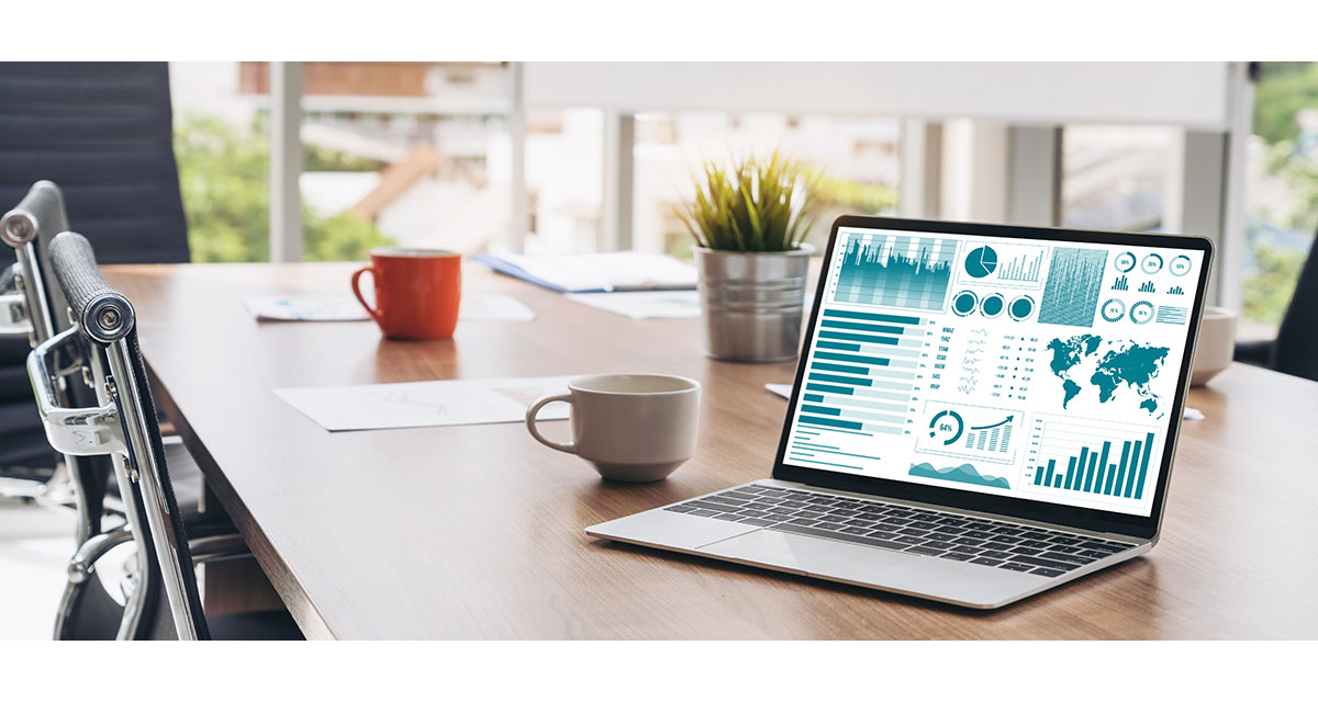 A laptop displaying a revenue analytics dashboard on a boardroom table