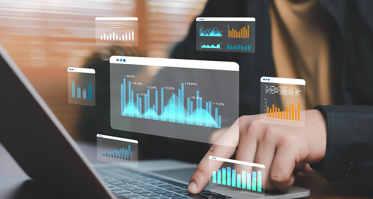 A hand typing on a laptop keyboard beneath floating translucent usage and revenue charts showing bar graphs and percentage gains
